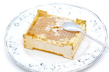 Honeycomb in a wooden frame on a plate 