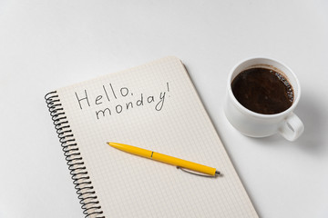Hello monday motivation notice. Notepad, pen and cup of coffee on white background.