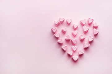 Pink heart-shaped marshmallows stacked on a pink background with space for copy. Marshmallow heart.Valentine's day concept theme in vintage style.