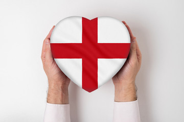 Flag of England on a heart shaped box in a male hands. White background