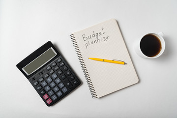 Copybook with Budget planning text. Notebook with calculator and cup of coffee on white background....