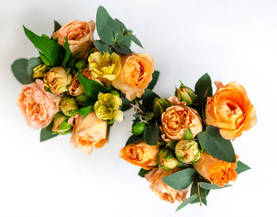 flower arrangement of orange roses and green leaves of eucalyptus in a vintage pot on a white background. partial blur. concept of holiday, love, compliment