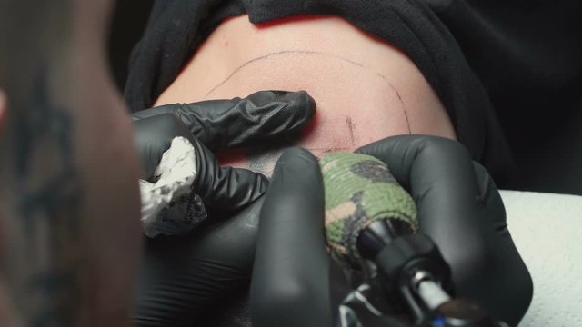 Man tattooist getting tattoo of snake for woman
