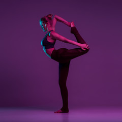 Obraz na płótnie Canvas Yoga pose standing class. Slim fit girl involved in stretching sports. Work on yourself exercise fitness exercises for women. Asana relaxation harmony balance. The trend color is neon. Place for text