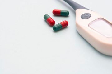 Close up pills - health care concept with thermometer on background. Health and medicine. Copy space.