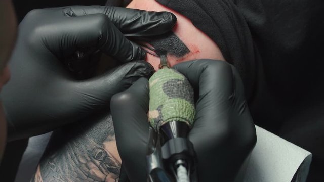 Video of man tattooist getting tattoo of snake, closeup