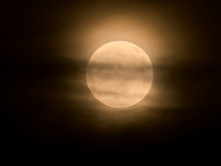 Full moon behind the clouds