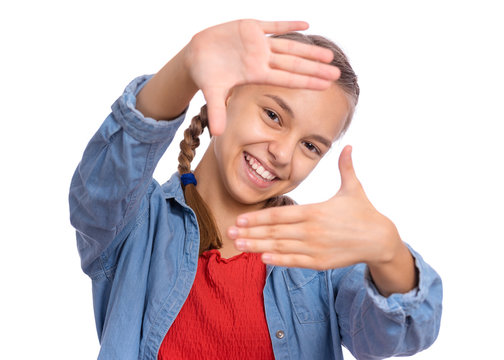 Portrait of teen girl making frame with hands and fingers with happy face, isolated on white background. Positive teenager making square with her fingers, looking at camera and pleasantly smiling.