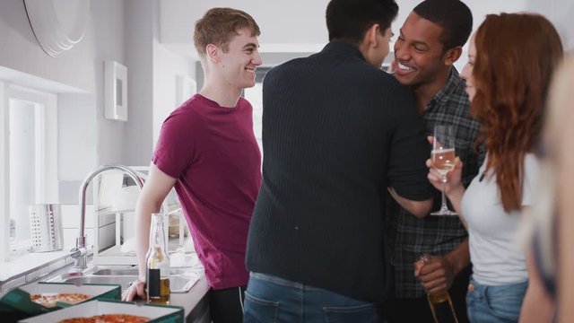 Group Of College Students In Shared House Greeting Friends Arriving For Party