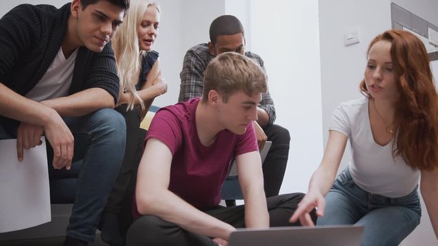 Group Of College Students In Shared House Bedroom Studying Together