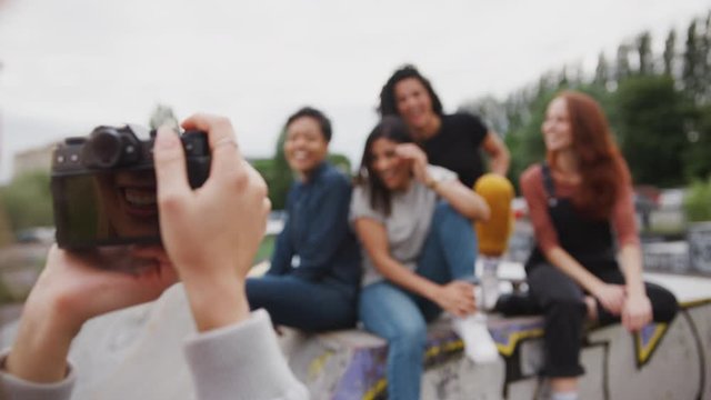 Group Of Female Friends Posing For Photo On Camera In Urban Skate Park