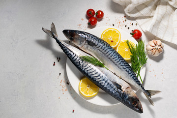 Raw organic mackerel with vegetables and spices on white marble kitchen table. Sea food concept....