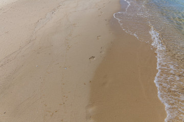 human footprints in the sand on the ocean. Sand Texture. Background from brown sand.
