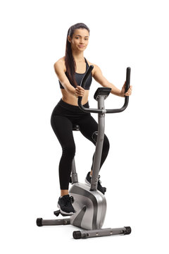 Young sporty female exercising on a stationary bike
