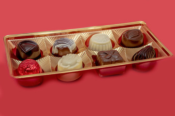 chocolates in gold packaging on a red background