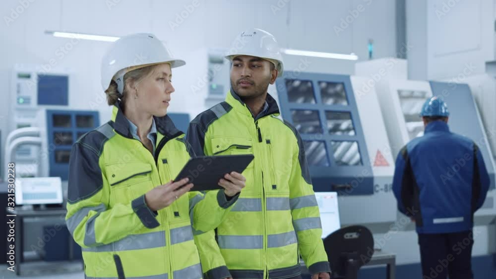 Aufkleber chief engineer and project supervisor in safety vests and hard hats walk through modern factory, tal