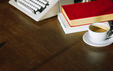 Place of work on wooden desk have old typewriter, note, book and coffee with sunlight in the...