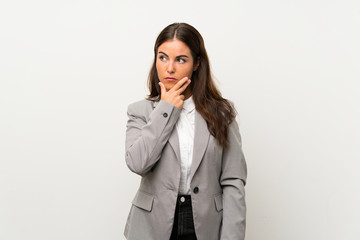 Fototapeta premium Young business woman over isolated white background thinking an idea