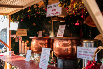 Very tasty hot gluhwein or mulled wine in two cauldrons on fire in the Christmas market around the...
