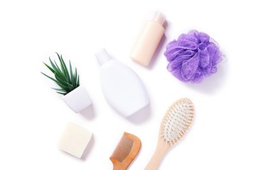Flat lay photo organic bath products with natural ingredients. Herbal shampoo, hair balm, handmade soap, wooden comb and purple sponge