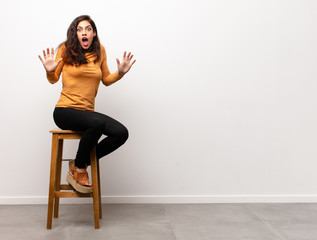 young pretty woman feeling happy and smiling casually, looking to an object or concept held on the...