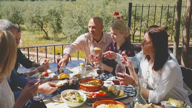 Company of six spends time at lunch in a open-air terrace