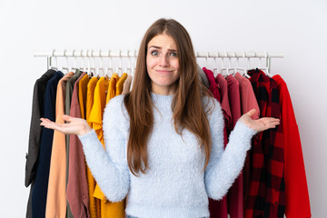 Young woman in a clothing store having doubts with confuse face expression