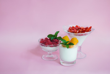 Homemade italian dessert panna cotta with fresh raspberry, apricots  and strawerry on pink background. Selective focus.