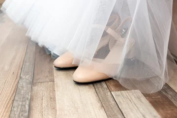 Foto op Plexiglas Behind the fabric hem of wedding dress are the bride’s wedding shoes © Sergei Gorin