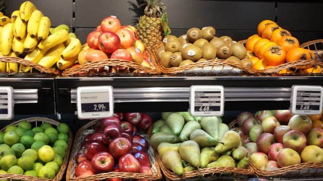 Fresh fruits in wicker baskets on shelf of supermarket