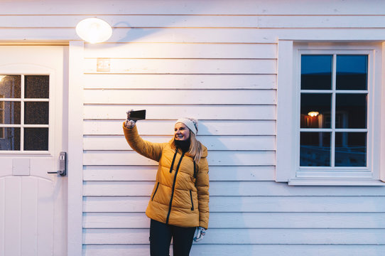 Tourist taking a selfie at a hut in Hamnoy, Lofoten, Norway