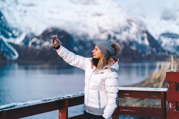 Happy tourist taking a selfie at Hamnoy, Lofoten, Norway