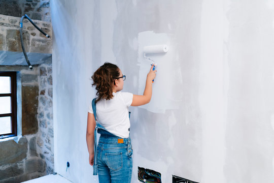 Girl Painting A Wall In A House