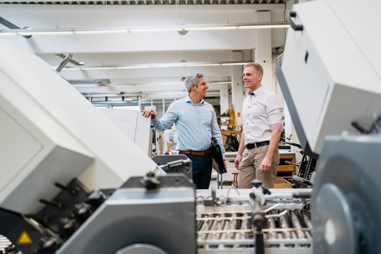 Two smiling colleagues in a factory
