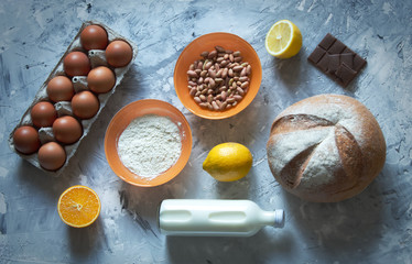Ingredients for cooking bread Cooking concept. Wheat dough and bottle of whole milk with eggs and peanut with lemon and orange