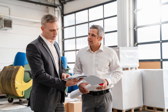 Two Businessmen Talking In A Factory