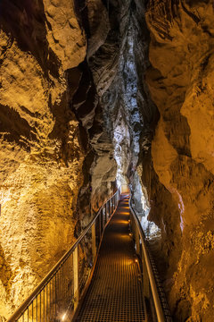New Zealand, Oceania, North Island, Waitomo Caves, Ruakuri Cave, Narrow walkway and limestone formations in cave