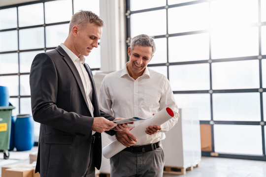 Two Businessmen Talking In A Factory