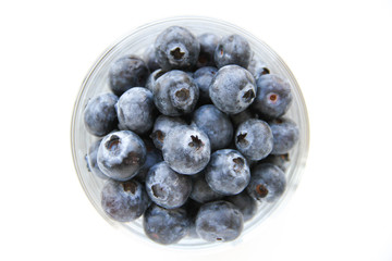Fresh blueberries in a small glass on a white background. Healthy eating. Vegan food. Top view.