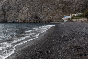 beaches with black volcanic sand and soft volcanic pebbles, with waves of white sea foam on the...