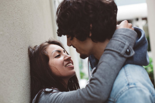 Young couple at house wall about to kiss