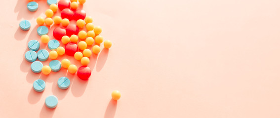 multicolored pharmaceutical pills thermometer a pink background. Copy space. the concept of health....