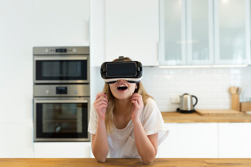 Female teenager in the kitchen with VR glasses