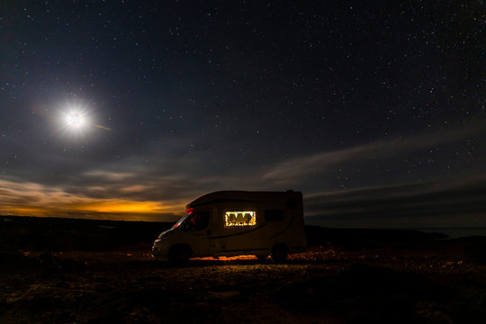 Lighted camper parking under starry sky, Es Mercadal, Menorca, Spain