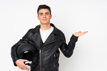 Man holding a motorcycle helmet isolated on white background holding copyspace imaginary on the palm