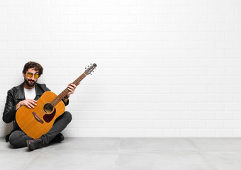 young musician man feeling confused and doubtful, wondering or trying to choose or make a decision...