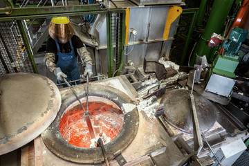 Skilled worker at the aluminum melt preparing the raw material for die casting