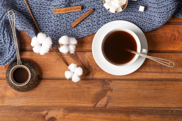 Fototapeta na wymiar flower of cotton and coffee on a knitted blanket, cozy home photo, flat lay