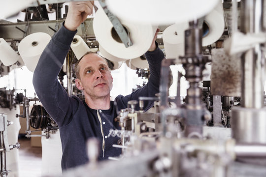 Man working at a machine in a textile factory