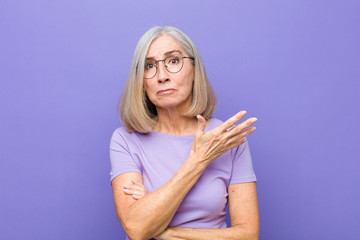 senior or middle age pretty woman feeling confused and clueless, wondering about a doubtful...